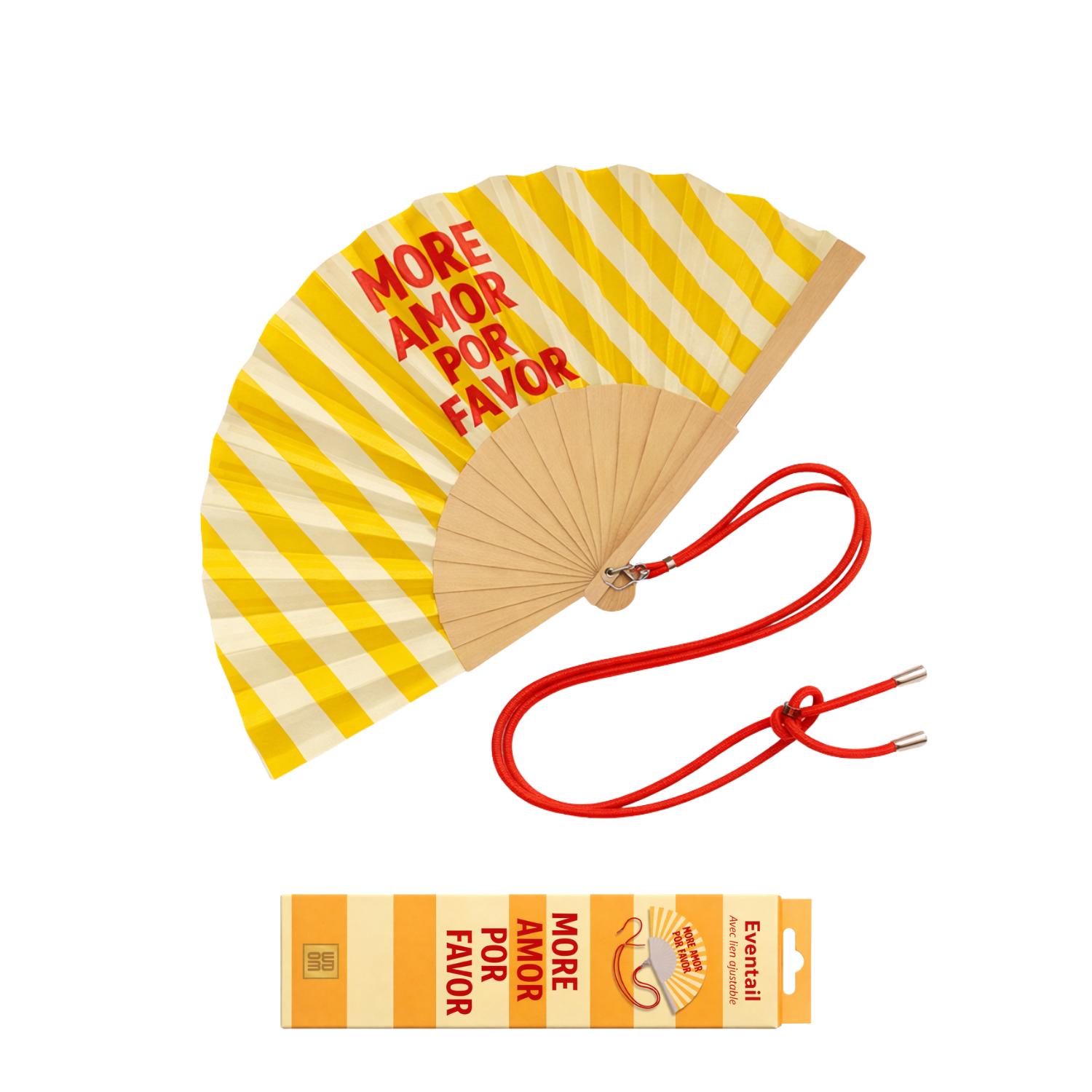 Éventail « More Amor Por Favor » présenté avec sa boîte cadeau assortie, aux rayures jaunes et crème. Un duo coloré et estival, idéal à offrir ou à s’offrir.