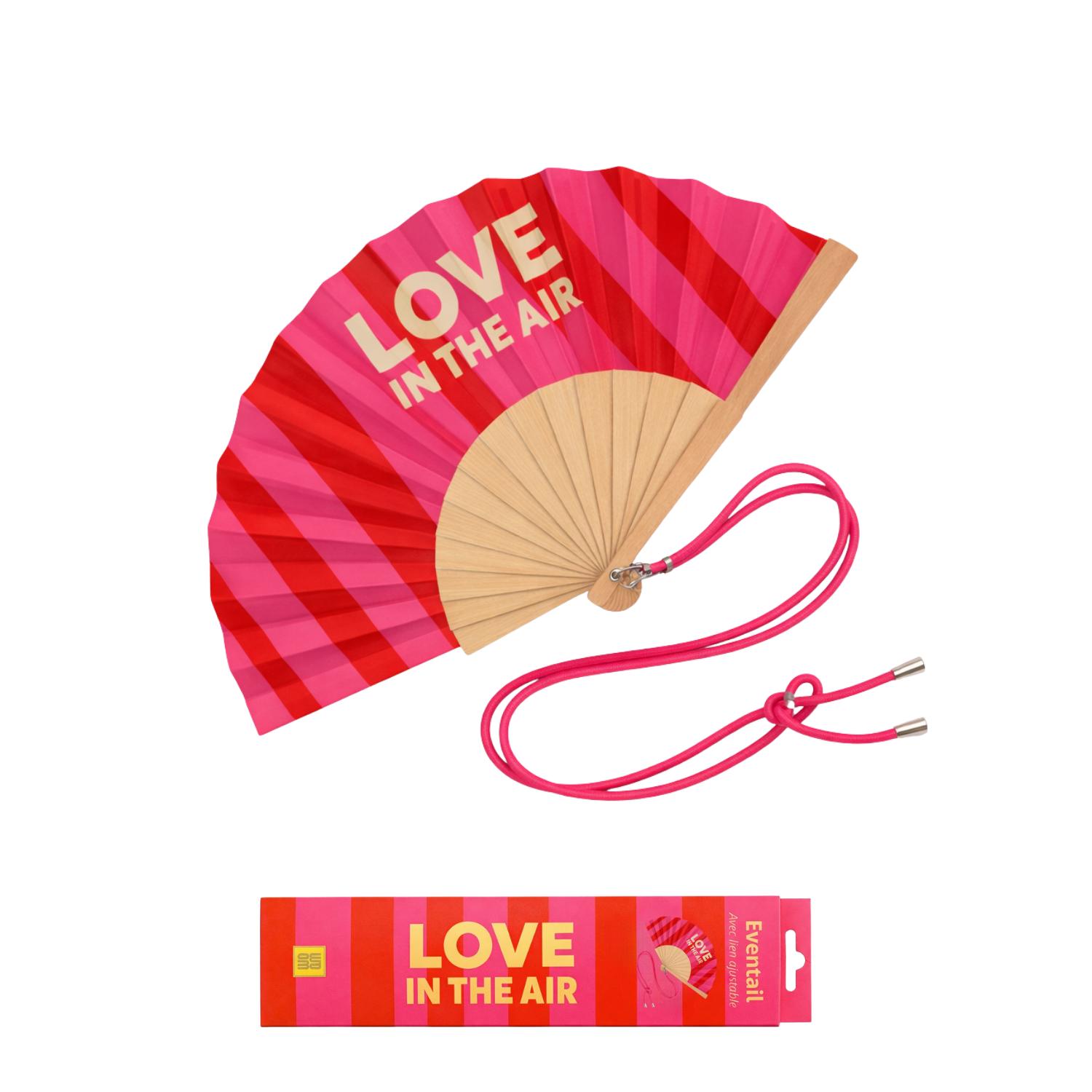 L’éventail LOVE IN THE AIR présenté avec sa boîte cadeau assortie.
Un duo ultra désirable, parfait à offrir ou à s’offrir, qui combine design graphique, message fun et packaging coloré.
