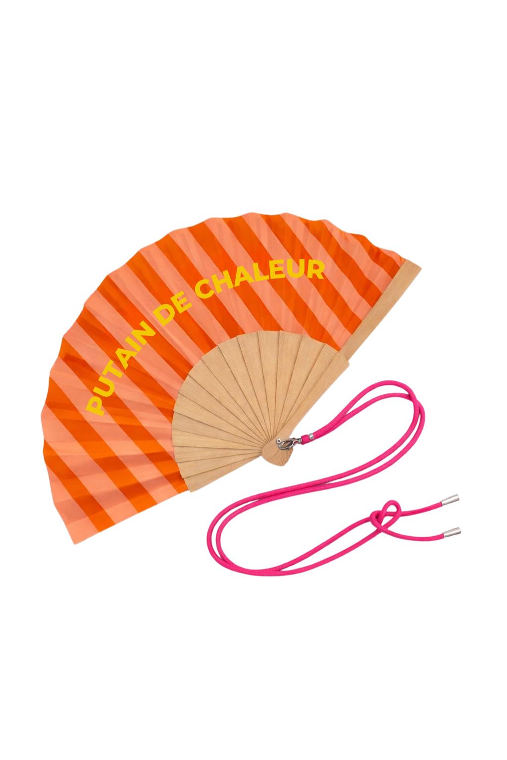 Éventail avec bandoulière ajustable “Putain de Chaleur”, motif rayé orange et rose avec message jaune. Léger, maniable et idéal pour affronter les fortes chaleurs avec humour.
